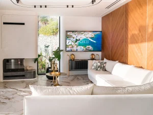 Stylish living area with modern decor, marble flooring, and panoramic windows.