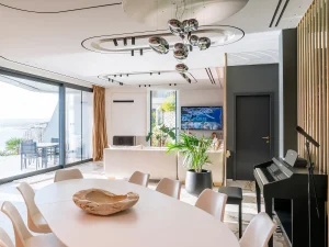 Bright dining room with round table and sea-view balcony.