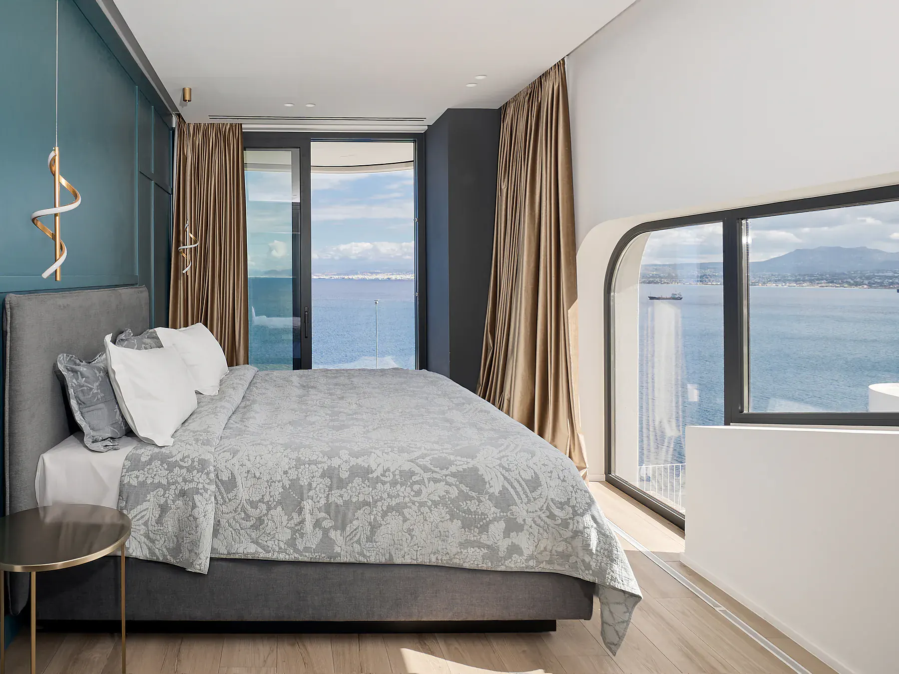 Minimalist bedroom with glass balcony overlooking the Mediterranean.