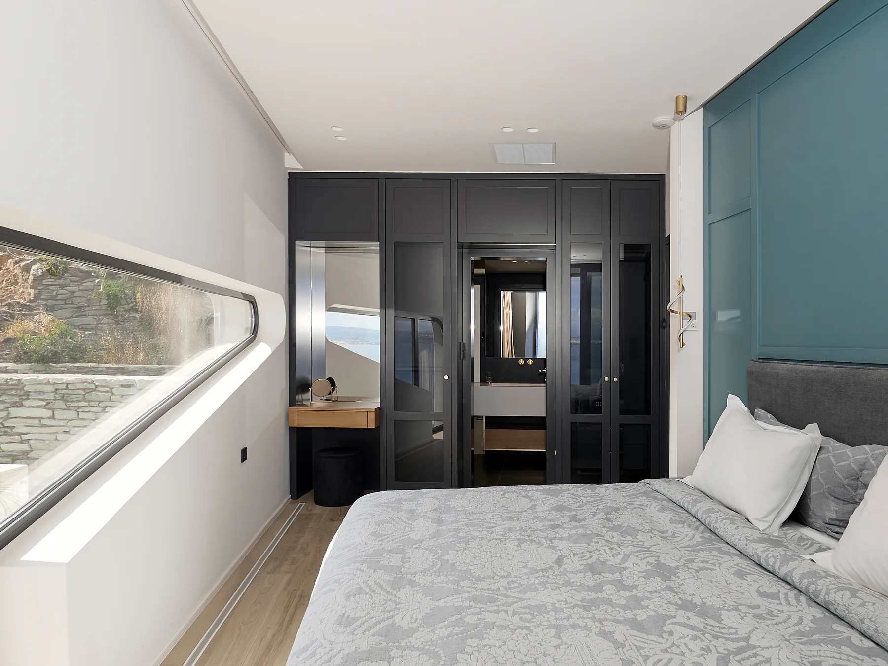 Bedroom with modern furnishings and elegant dark-wood wardrobe.